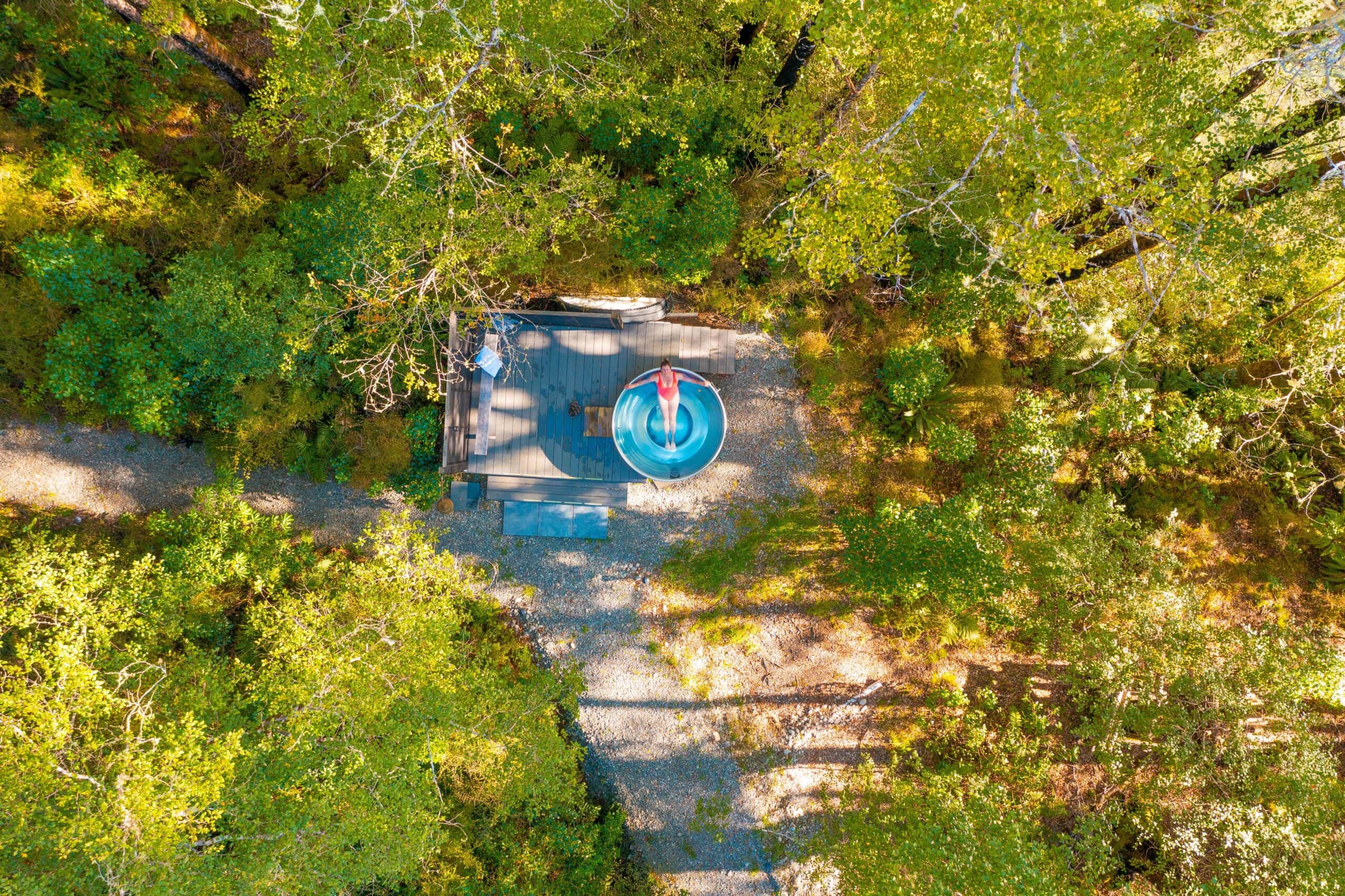 aerial view of lady in a hot tub in a forrest setting